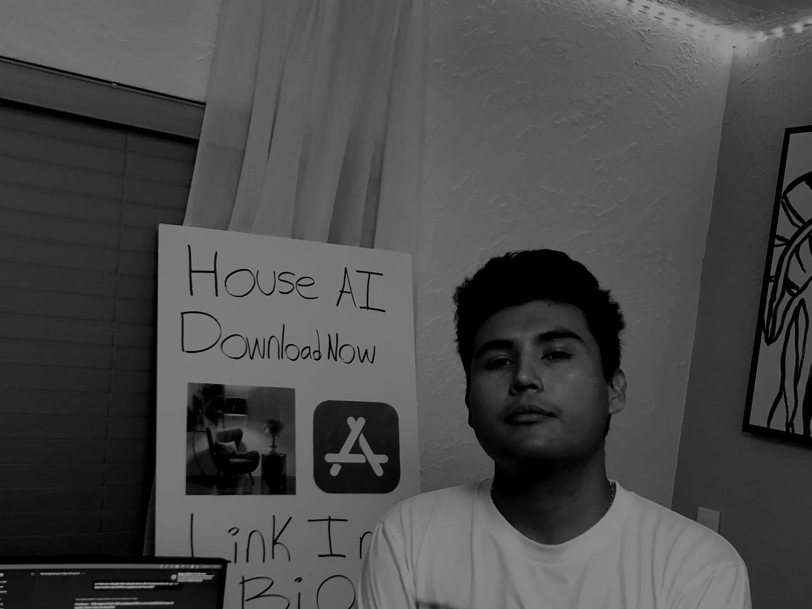 Jeffrey Escobar, Founder of House AI, at his desk with a handmade House AI download poster in January 2026