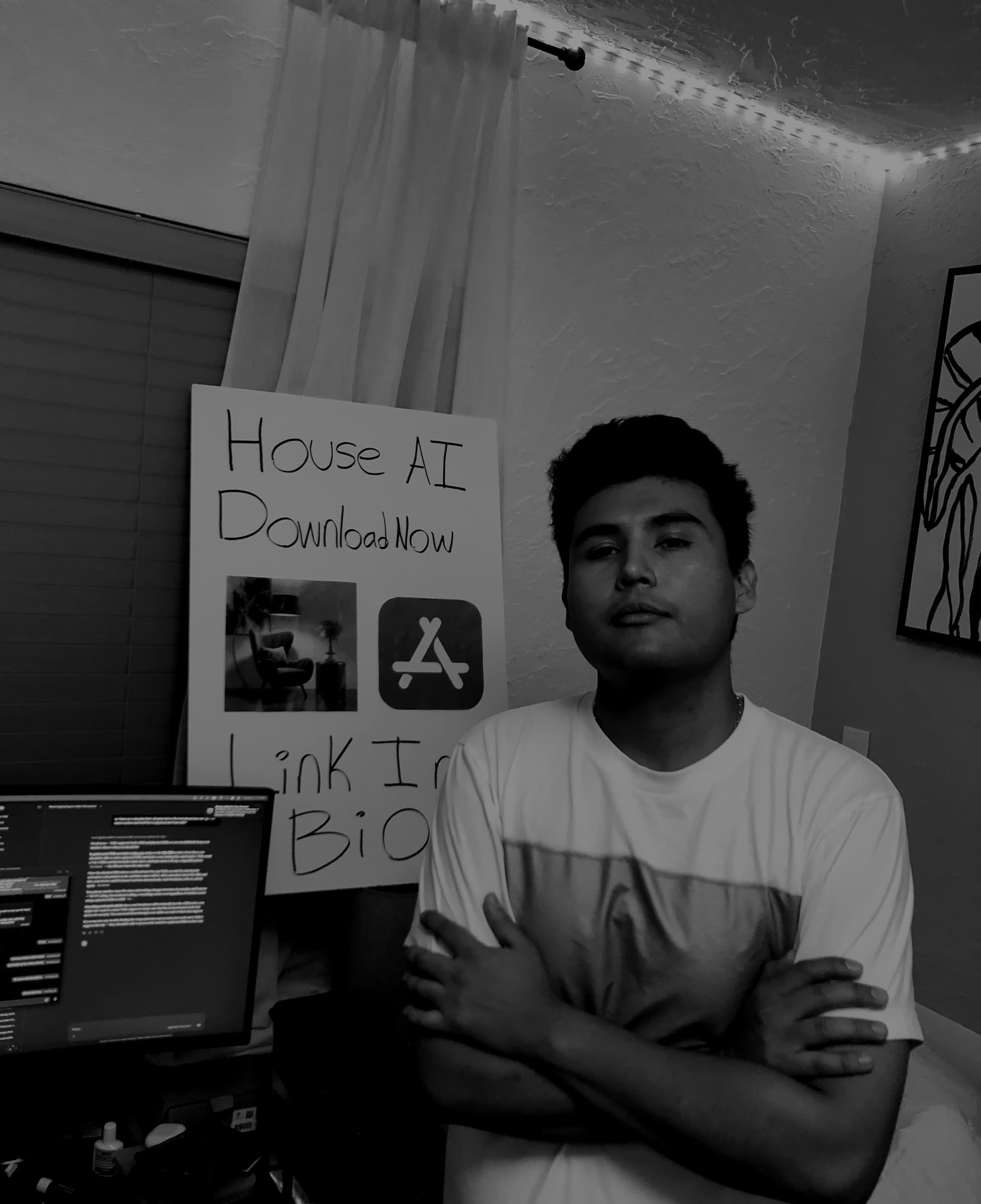 Jeffrey Escobar, Founder of House AI, at his desk with a handmade House AI download poster in January 2026