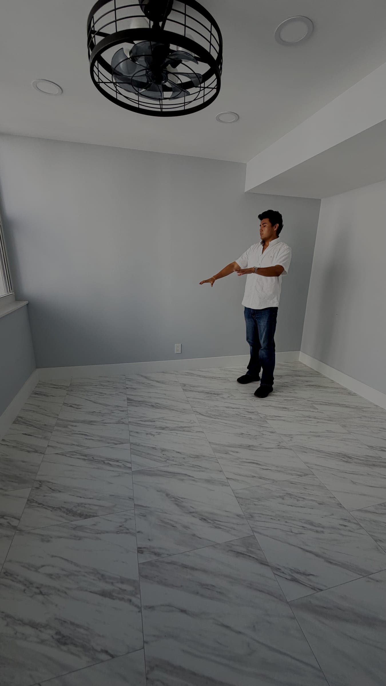 Jeffrey Escobar planning furniture placement in an empty room while verifying a House AI design concept on site