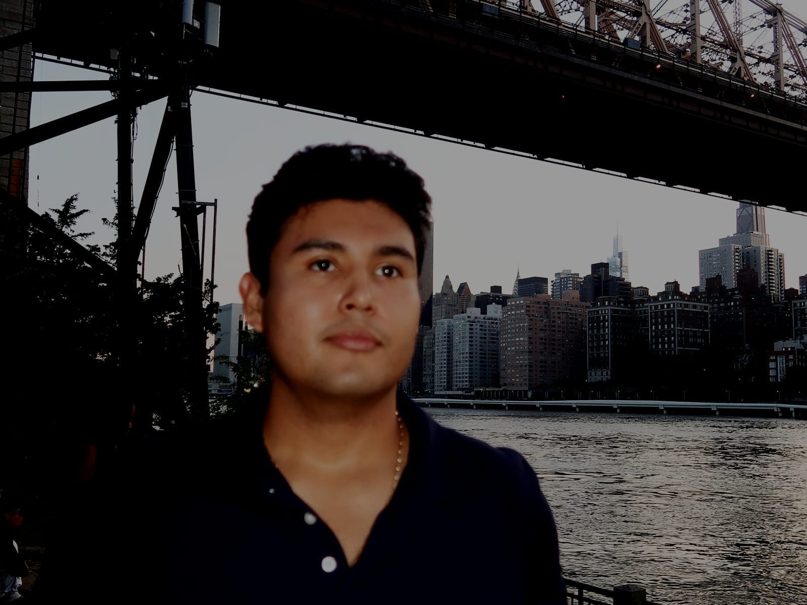 Jeffrey Escobar in New York City at dusk, with the Queensboro Bridge and Manhattan skyline behind him