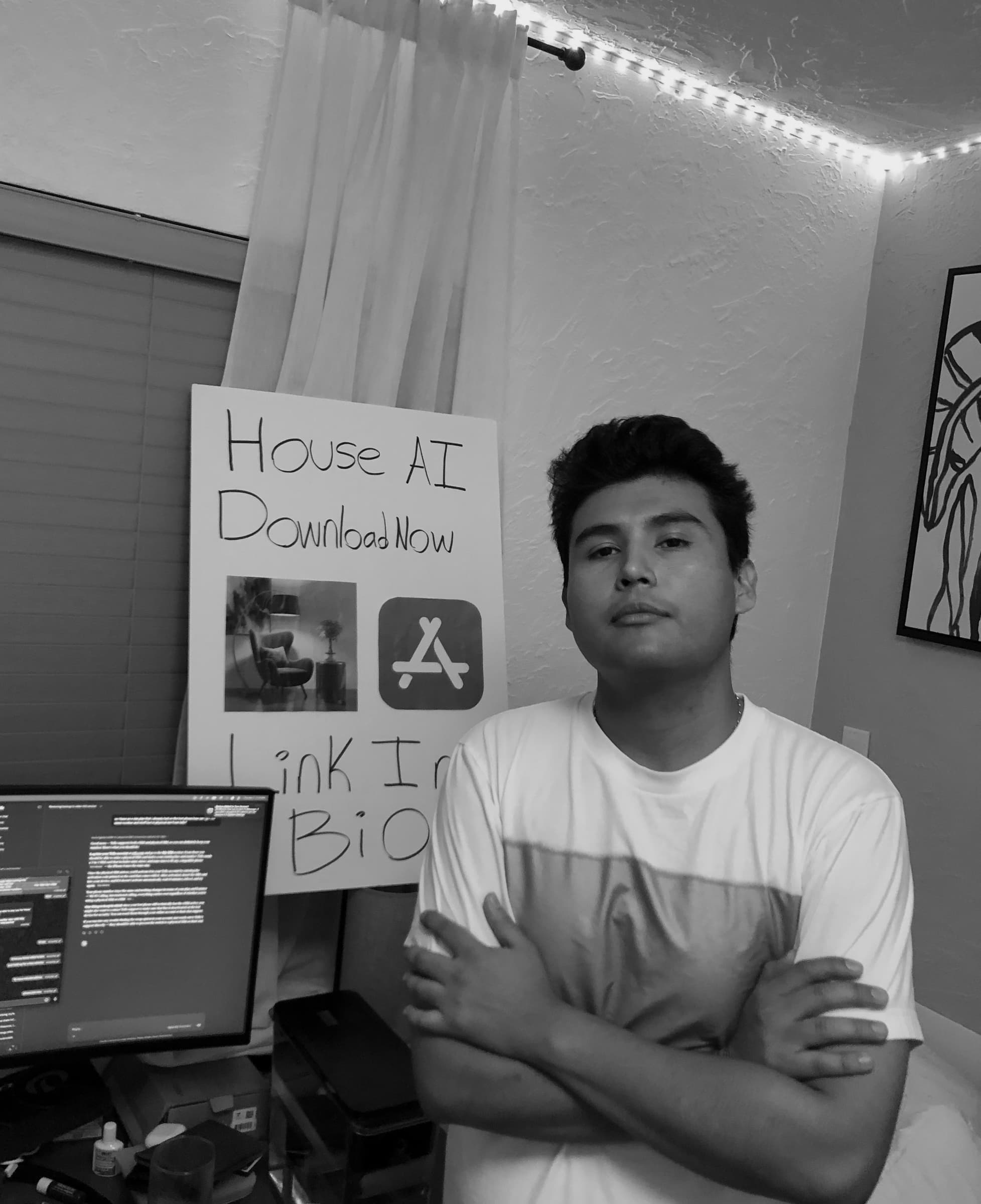 Jeffrey Escobar, Founder of House AI, at his desk with a handmade House AI download poster in January 2026