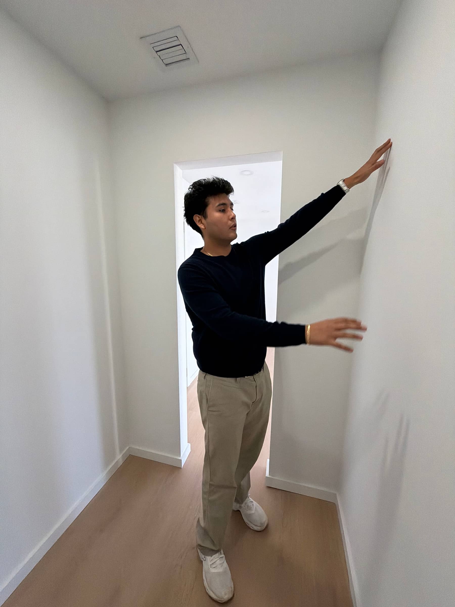 Jeffrey Escobar measuring wall space while verifying a House AI generated design on site in Miami Beach, Florida, January 2026