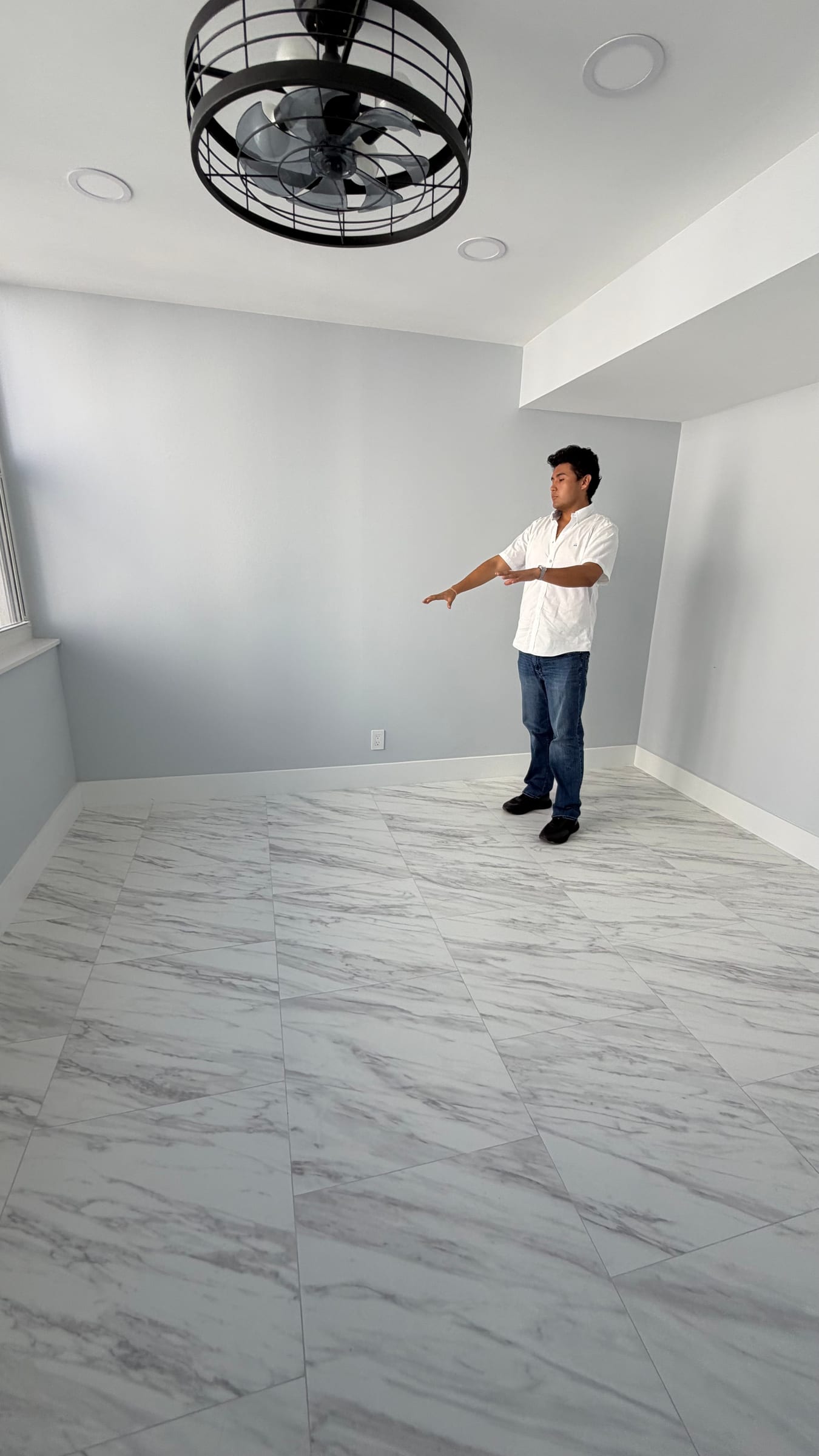 Jeffrey Escobar planning furniture placement in an empty room while verifying a House AI design concept on site