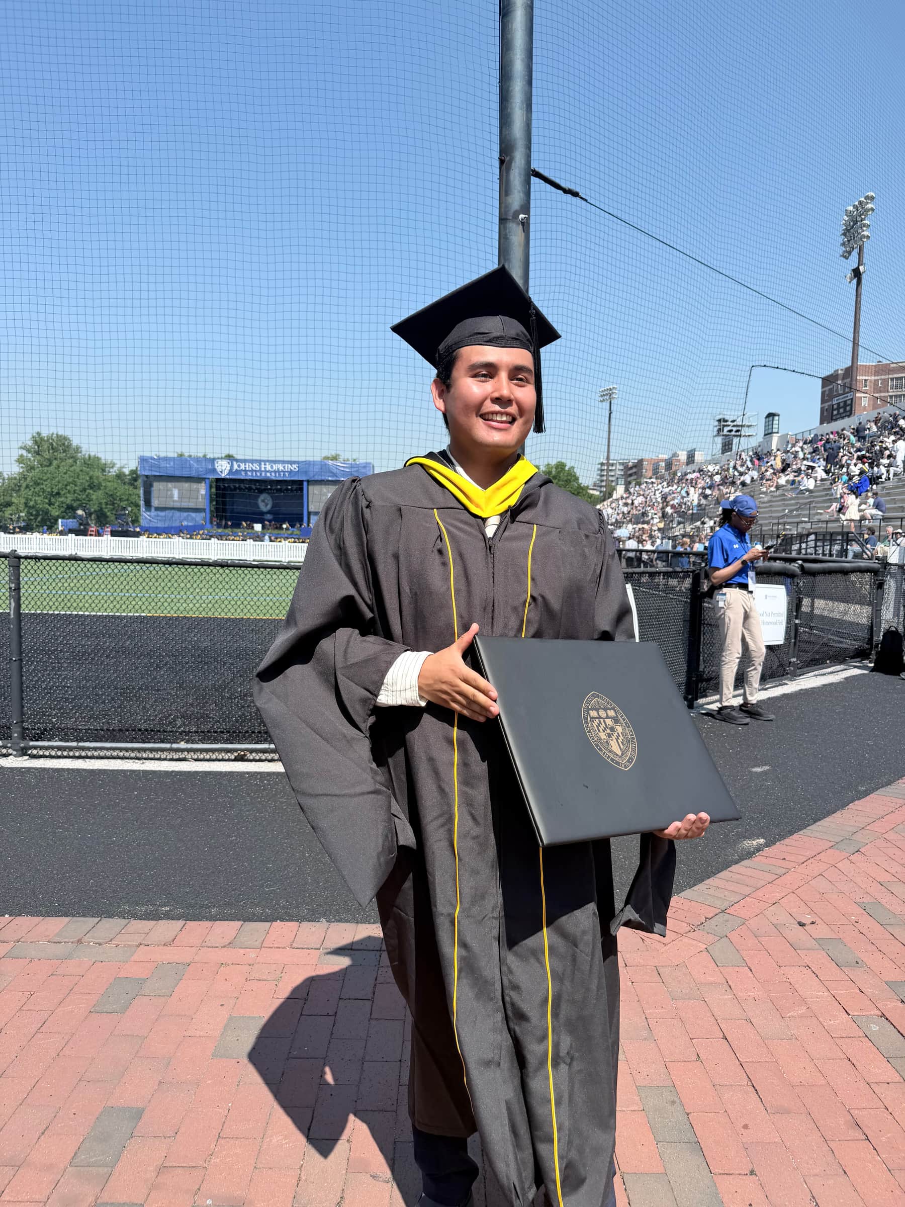 Jeffrey Escobar graduating from Johns Hopkins University in computer science at Homewood Field in May 2026, holding his diploma