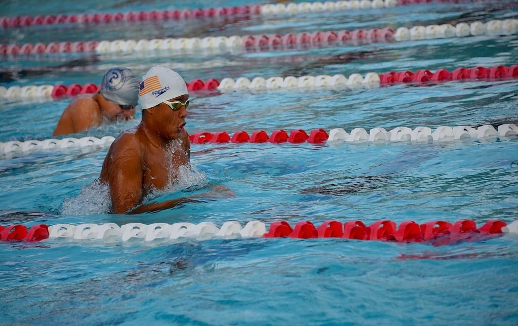 Jeffrey Escobar swimming breaststroke at a varsity swimming competition where he won 1st place